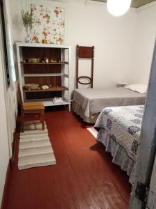 een kamer met 2 bedden en een houten vloer bij Doña Irene B & B in Rancagua