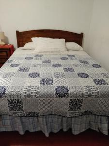 a bed with a blue and white quilt on it at Doña Irene B & B in Rancagua