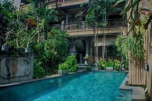 ein Schwimmbad in der Mitte eines Gebäudes mit Pflanzen in der Unterkunft Rumah Roda in Ubud