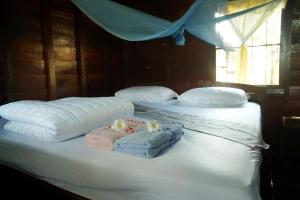 Un par de camas con toallas y almohadas. en The Boathouse en Ban Dondét