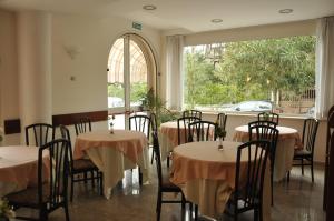 una sala da pranzo con tavoli, sedie e una finestra di Florentia Hotel a Lido di Camaiore