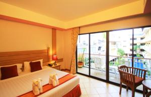 a hotel room with a bed and a balcony at Baan Boa Resort in Patong Beach
