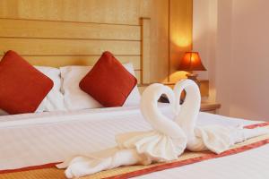 two white swans sitting on top of a bed at Baan Boa Resort in Patong Beach