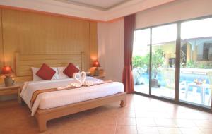a bedroom with a bed and a large sliding glass door at Baan Boa Resort in Patong Beach