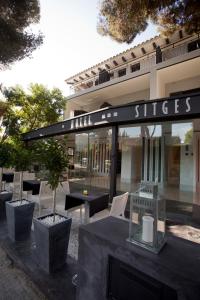 a restaurant with tables and chairs in front of a building at Hotel Sitges in Sitges