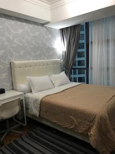 una camera da letto con un letto, un tavolo e una scrivania di Luxury 2 BR Condo at Casa Grande Residence - Kasablanka Mall a Giacarta