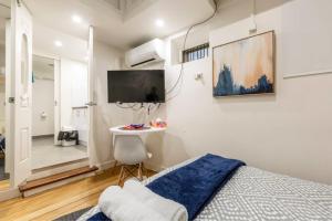 a bedroom with a bed and a tv on the wall at Readyset Apartments on Anthony in Melbourne