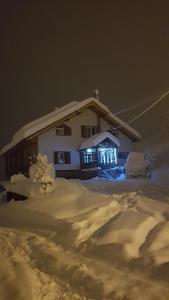 een huis bedekt met sneeuw 's nachts bij Gagieti in Goedaoeri