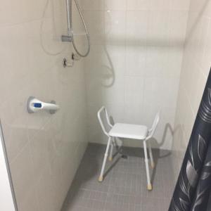 a shower with a white chair in a bathroom at Altona Garden Retreat in Spreyton