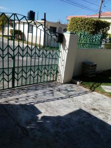 a gate in front of a white fence at Cozy & Comfy in Portmore
