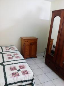Schlafzimmer mit einem Bett, einer Kommode und einem Spiegel in der Unterkunft Cozy & Comfy in Portmore