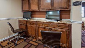 a room with a desk with a television and two chairs at Best Western Plus Lubbock Windsor Inn in Lubbock