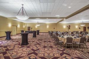 a banquet hall with tables and chairs in a room at Ramada by Wyndham Midtown Grand Island in Grand Island
