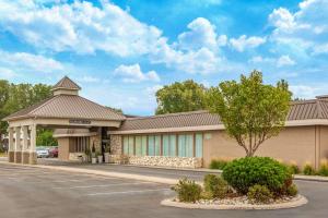 a building with a parking lot in front of it at Ramada by Wyndham Midtown Grand Island in Grand Island