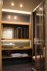een badkamer met een wastafel en een glazen douche bij Athlos Hotel in Thessaloniki