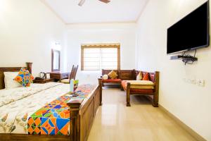 a bedroom with two beds and a flat screen tv at Hotel Raj Kothi Jaipur airport in Jaipur