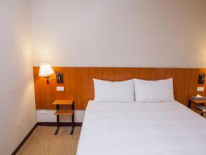 Una cama o camas en una habitación de Jiuwu Hotel