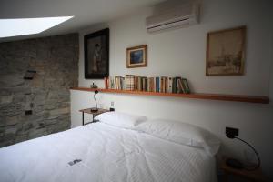 a bedroom with a white bed and a book shelf at B&B Convento S. Antonio in Como