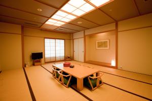 ein Zimmer mit einem Tisch in der Mitte in der Unterkunft Hotel Kitano Plaza Rokkoso in Kōbe