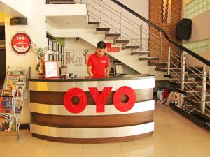 a man standing behind a counter in a store at Super OYO 107 Orange Nest Hotel in Manila