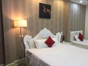 a bedroom with a white bed with red pillows at HD Hotel Nội Bài in Noi Bai