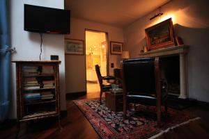 uma sala de estar com uma televisão, uma cadeira e uma lareira em B&B Convento S. Antonio em Como