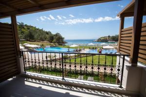 a balcony with a view of a pool and the ocean at Thassos Grand Resort in Alyki