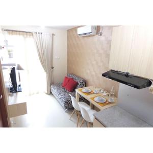 een kleine woonkamer met een tafel en een keuken bij Premium One Bedroom at Woodland Park Residence in Jakarta