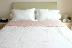 ein großes weißes Bett mit weißen Kissen und einer weißen Bettdecke in der Unterkunft Premium One Bedroom at Woodland Park Residence in Jakarta