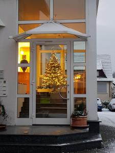 ein Weihnachtsbaum im Fenster eines Hauses in der Unterkunft Hotel Zur Eisenbahn in Renningen