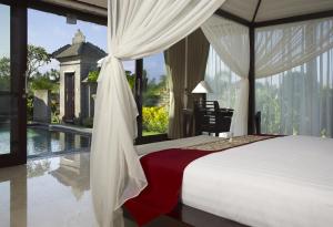 - une chambre avec un lit et une piscine dans l'établissement Santi Mandala Villa & Spa, à Sukawati