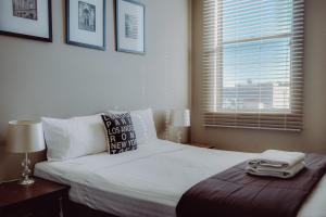 a bedroom with a large white bed with a window at Crossroads Hotel in Narrabri