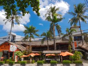 a restaurant with orange umbrellas and palm trees at Taman Unique Hotel in Senggigi
