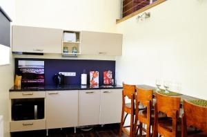 a kitchen with white cabinets and a table with chairs at Embrace Hotel & Apartments in Pärnu