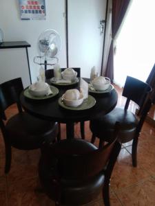 a black table with plates and bowls on it at Overflow Guest House in Gaborone