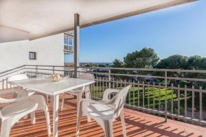 patio con mesa blanca y sillas en el balcón en Agaró Cambrils Apartments en Cambrils
