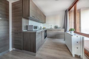 una cucina con armadi in legno e forno a microonde di Agaró Cambrils Apartments a Cambrils