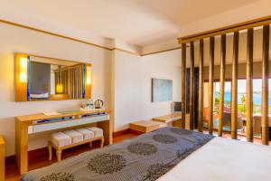 - une chambre avec un lit, un bureau et un miroir dans l'établissement Kefaluka Resort, à Akyarlar