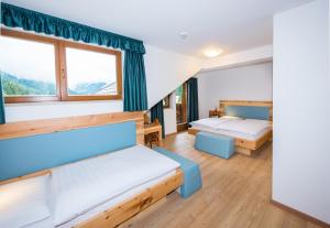 Zimmer mit 2 Betten und 2 Fenstern in der Unterkunft Hotel Feldrand in Weissenbach