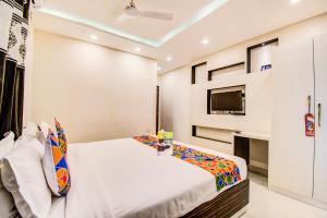 a bedroom with a bed and a tv at FabHotel Corporate Crown Koramangala in Bangalore