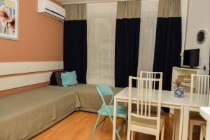 een kleine kamer met een bed en een tafel en stoelen bij Apartment Coral in Pomorie