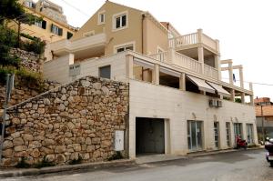 a building with a stone wall next to a house at Apartments Annette - studio and two bedroom apartment with parking in Dubrovnik