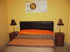 een slaapkamer met een bed met 2 nachtkastjes en 2 lampen bij Hostal el mirador in Higuera de Llerena