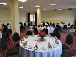un salón de banquetes con mesas y sillas con platos y tazas en Turmhotel Schwedt en Schwedt