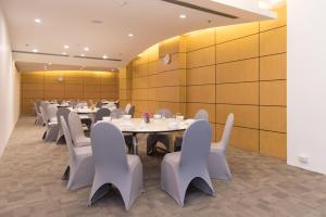 a dining room with white tables and white chairs at Gold Orchid Bangkok Hotel in Bangkok +101 photos