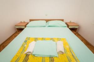 a bedroom with a bed with two nightstands and towels on it at Villa Gloria in Potomje