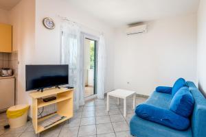 a living room with a blue couch and a television at Villa Gloria in Potomje