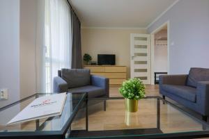 a living room with two chairs and a coffee table at RentPlanet - Apartament Kościelna in Zakopane
