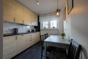 a kitchen with wooden cabinets and a table with chairs at RentPlanet - Apartament Kościelna in Zakopane