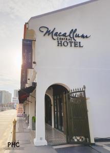 a white building with a sign for a hotel at Macallum Central Hotel by PHC in George Town